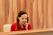 © Guys Who Shoot - A girl administrator of a medical center sits at the reception and makes appointment for patients to see doctor by phone