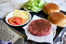 Still Life Hamburger Patty And Ingredients On Tray
