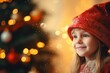 A girl in a Santa hat against the background of a Christmas tree and Christmas lights