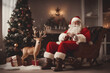 Santa Claus under the Christmas tree, Christmas decorations, a reindeer and a sleigh with presents stand nearby