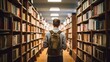 © Robert - Rear view of a male student standing in a library and searching for books