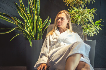 Wall Mural - Woman in white bathrobe lying on sofa and relaxing at SPA.