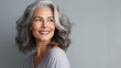 A woman with smooth healthy face skin. Beautiful aging mature woman with gray hair and happy smiling touch face