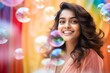 © vasyan_23 - happy smiling indian woman on colorful background with rainbow soap balloon with gradient