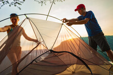 A Young Woman And Man Set Up A Tent At A Campsite Overlooking A Gorge On A Cliff In Tennessee