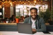 © vasyan_23 - happy african american man sitting at table with laptop in cafe