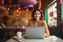 Happy Indian Woman Sitting At Table With Laptop In Cafe