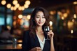 © vasyan_23 - happy modern asian woman with a glass of expensive wine on the background of a fancy restaurant and bar