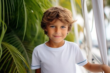 Wall Mural - happy modern child boy against the background of a yacht and tropical palm trees