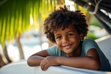 Wall Mural - happy modern african american child boy against the background of a yacht and tropical palm trees