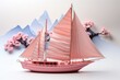 © Friedbert - A pink model of a sailboat with mountains in the background