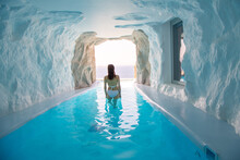 Woman Is At Cave Style Pool With Sea View