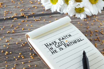Wall Mural - Have faith in God, He is Faithful. Inspiring Christian bible quote handwritten in notebook with mustard seed and flowers on wooden table. Biblical promise, peace, trust, and belief in Jesus Christ.