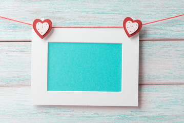 Wall Mural - Blank turquoise plaque hanging on clothespins in the shape of a heart. Valentine's Day concept