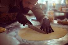 Focused Chef Cutting Dough For Pastry