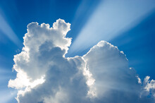 Cloud Formations Against A Blue Sky With Sun Rays 