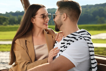 Wall Mural - Romantic date. Beautiful couple spending time together on swing bench outdoors