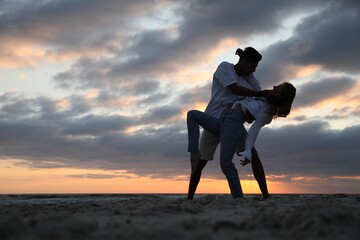 Poster - Happy couple dancing on beach at sunset