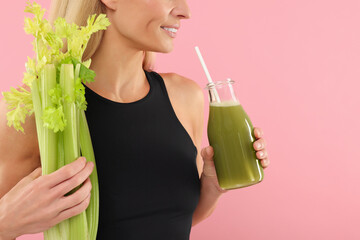 Poster - Woman with glass bottle of tasty celery juice and fresh vegetable on pink background, closeup