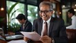 © yj - Happy senior Indian businessman investor bank client checking document at office team meeting with financial law experts attorneys team. generative AI