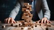 Businessman building a tower of wooden blocks. Business success and strategy concept