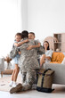 © Pixel-Shot - Little children hugging their military father at home