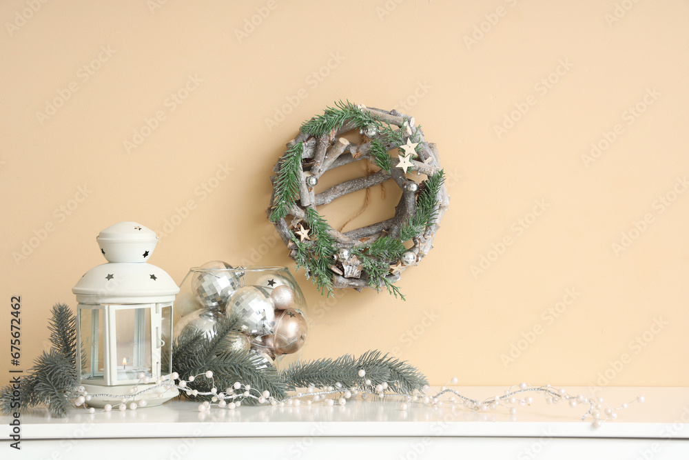 Christmas lantern with fir branches and balls on shelf in room