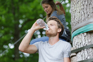 young man is drinking water in nature