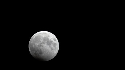 Wall Mural - Nearly full moon at beginning of lunar eclipse moves across October night sky 2023