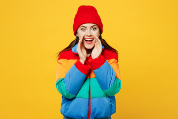 Wall Mural - Young woman she wears padded windbreaker jacket red hat casual clothes scream sharing hot news about sales discount with hands near mouth isolated on plain yellow background studio. Lifestyle concept.