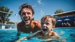 © sirisakboakaew - Father and son playing in the swimming pool