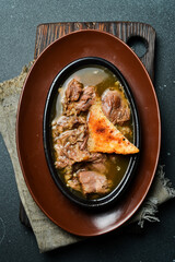 Wall Mural - Veal stew on a plate. Close up. On a dark background.