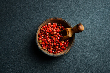 Wall Mural - A bowl of red pepper peas. On a black background. Top view. Free space for text.