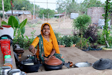 Indian woman making food on traditional kitchen. rural india, The woman is cooking food with the help of natural equipment