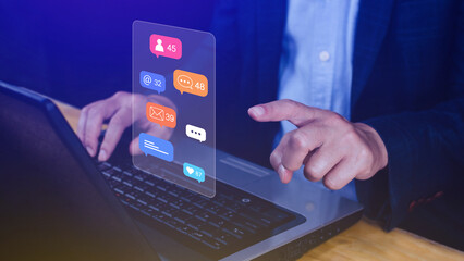 People using touching social media and digital online marketing concepts on laptop with icons such as notifications, messages, comments on the screen.