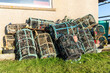 Traditional lobster pots or crab pots stacked up on the quayside in the fishing village of Caithness, Scotland