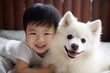 Young asian child playing with samojed dog