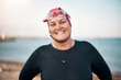 © Flamingo Images - Woman wearing a wetsuit and cap smiling before an open water swim