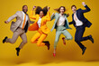 Diverse business people jumping over yellow background celebrating success.