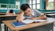© Marko - bored asian student sleeping on his desk in the school classroom. holding his head with his hand