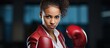 © TheWaterMeloonProjec - In the isolated background of a business gym a young African American woman a beautiful and powerful young adult is seen confidently boxing while managed by a strong and determined business
