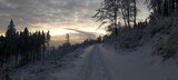 Fototapeta Tęcza - Śnieżna droga o zachodzie słońca