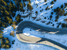 Aerial photo of a snowy Andorran mountain road winding through winter landscapes.