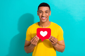 Poster - Photo of famous blogger young man hold paper heart symbol subscribe his popular youtube like notification isolated on cyan color background