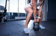Female athlete exercising with kettlebell indoors. Strong woman working out with a kettle bell in a gym
