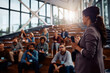 © Drazen - Female business leader talks to group of seminar attendees at convention center.