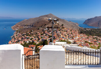 Wall Mural - Aerial view of colorful traditional multi-colored houses on a mountainside on Symi island.