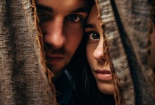 close up of a couple hiding their faces from someone behind textile curtains, emotional stytelling