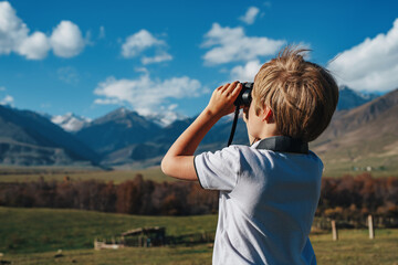 Sticker - Boy with binoculars in the mountains looking into the distance