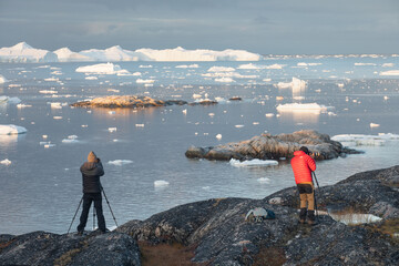 Wall Mural - Man taking picture with a digital SLR camera in west Greenland
Photographers in Ilulissat Icefjord, Greenland
Melting of a iceberg and pouring water into the sea